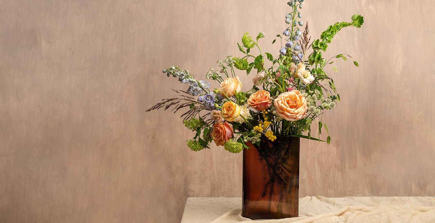 NUDE Mist vase in caramel lead free crystal, paired with tall blooms like delphinium, irises, foliage and grasses, created by Grace & Thorn