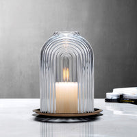 Lead-free crystal candle holder Ilo, a dome shaped candle holder with rippled glass effect, with candle presented on a table with grey tones